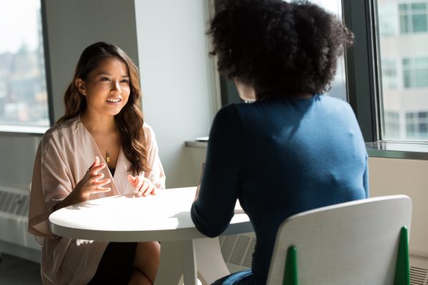 two women sitting at table during face to face coaching